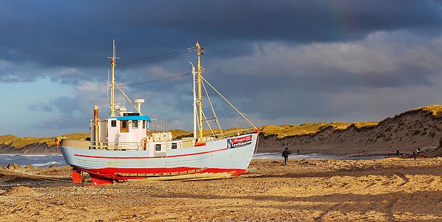 Beached fishing boat in late afternoon sun, Slaunger, Wikimedia Commons, CC-BY-SA-3.0